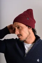 Gorro de lana tejido en punto rib, color bordó, con diseño de doblez en el borde y etiqueta pequeña lateral.
