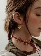 Aros tipo argolla dorada con dije colgante en forma de estrella de acrílico color rosa.