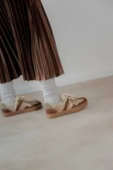 Championes urbanos de diseño acolchado, combinando tonos marrones, beige y detalles metalizados con textura. Cuentan con cordones al tono y suela de goma color caramelo.