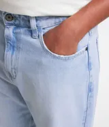 Pantalon de jean gris con lavado deslavado, de corte baggy y silueta holgada. Cuenta con bolsillos al frente y atras, y cierre de boton y cremallera.