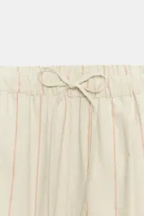 Pantalón culotte de lino en color beige con finas rayas verticales anaranjadas, tiro alto, cintura elástica con cordón de ajuste y bolsillos laterales.