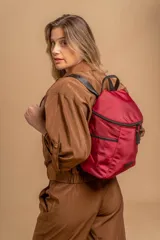 Mochila urbana de diseño compacto en color negro, confeccionada en nylon resistente. Cuenta con un compartimento principal con cierre, bolsillo frontal con cierre y correas ajustables con detalle de marca.