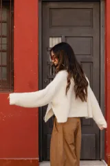 Buzo tejido en mohair de corte crop, con cuello redondo, mangas largas y tajos laterales en el ruedo.