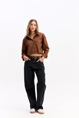 Camisa crop de corte relajado, con cuello clásico, cierre frontal de botones y mangas largas con puños. Confeccionada en algodón, presenta un diseño versátil y moderno.