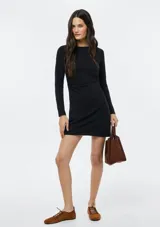 Vestido corto negro de manga larga, con escote redondo y silueta ajustada.