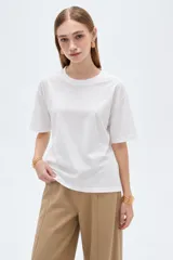 Remera blanca de manga corta, cuello redondo a la base y diseño holgado, confeccionada en algodón.
