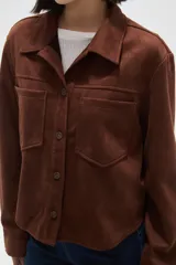 Sobrecamisa de textura gamuzada en color negro, con cuello clásico, cierre frontal de botones y dos bolsillos frontales con solapa.