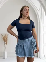 Remera negra ajustada al cuerpo, con escote cuadrado y mangas cortas.