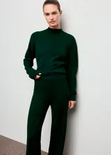 Pantalón de punto color verde oscuro, de tiro medio, diseño recto y largo, con cintura elástica y detalle de costuras.