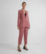 Pantalón rosado de liocel con cintura ancha y pespuntes, cierre frontal con cremallera, dos bolsillos laterales y bajo diagonal.