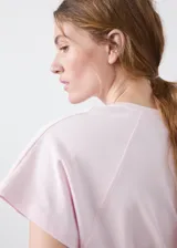 Camiseta de algodón color rosado, con diseño recto, cuello redondo y manga corta.