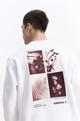 Buzo de algodón color celeste, con cuello redondo, puños y bolsillos laterales. Presenta estampados con texto en el pecho y un parche en la manga.