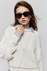 Sweater de tejido tramado color blanco con cuello redondo, mangas largas de hombro caído y terminaciones en rib.