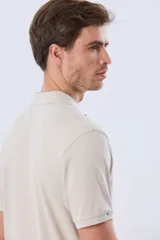 Remera polo de piqué de algodón color azul, de manga corta, con cuello camisero, cierre frontal de dos botones y pequeño logo bordado en el pecho.