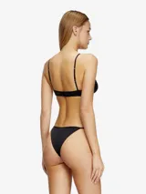 Bombacha negra de tiro alto confeccionada en microfibra suave, con aplique metálico Oval D en la cadera izquierda.