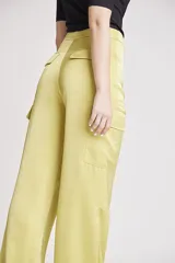 Pantalón de vestir color verde oliva, de corte ancho y tiro alto, con bolsillos laterales tipo cargo y detalle de pinzas en la cintura.