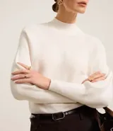 Blusa de punto acanalado color tostado, con cuello alto, mangas largas y puños ajustados. Confeccionada en viscosa, poliéster y poliamida.