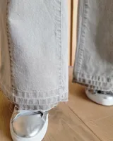 Pantalón de jean estilo wide leg con costuras verticales frontales, tiro alto y bolsillos laterales.