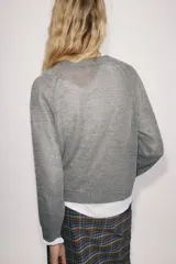 Chaqueta de punto gris con mezcla de lana, cuello redondo y manga larga. Cierre frontal con botones nacarados.