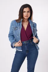 Chaqueta de jean azul con apliques de strass, cuello clásico, cierre frontal con botones metálicos, bolsillos con solapa en el pecho y ruedo desflecado.