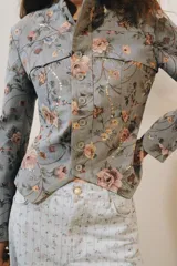 Blazer de jacquard de algodón con estampado floreado, cuello subido, manga larga y cierre frontal con botones. Presenta bolsillos de plastrón en el delantero, detalle de aplicación de lentejuelas, forro interior a tono y bajo asimétrico.