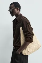 Bolso tipo shopper de tejido de algodón color beige, con diseño de red exterior y compartimento principal con cierre de imán. Cuenta con asa de mano oscura a contraste y bolsillos interiores.