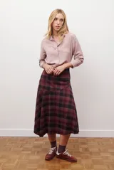 Camisa de mujer a rayas verticales blancas y rosadas, con cuello clásico, cierre de botones frontal y mangas largas con puños abotonados.