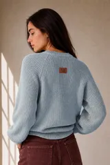 Buzo de tejido de punto celeste, con cuello redondo, mangas largas y diseño holgado.