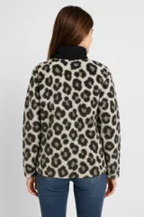 Buzo de poliéster con estampado animal print en tonos beige y gris, cuello alto negro con cierre de cremallera parcial y bolsillo tipo canguro.