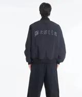 Campera bomber negra con cuello, puños y cintura acanalados. Presenta cierre frontal y bolsillos laterales. En la espalda tiene bordada la palabra "Bestia" en letras góticas blancas.