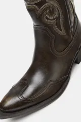 Bota cowboy de caña alta color marrón oscuro, con bordados a contraste y tacón medio en bloque.