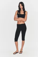 Pantalón capri de tiro medio confeccionado en tejido elástico, con cierre lateral mediante cremallera oculta.