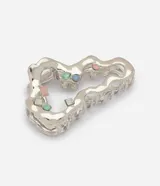 Pinza para el pelo de metal plateado con diseño orgánico y calado, decorada con pequeños cristales de colores.
