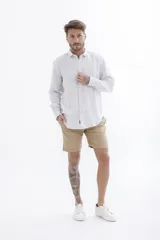 Camisa celeste a rayas verticales blancas, de manga larga y corte clásico.