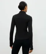 Campera deportiva Get Over de ajuste entallado, confeccionada en microfibra con malla térmica. Presenta cuello alto, cierre frontal con cremallera, mangas largas con orificio para pulgar y bolsillos laterales con cierre.
