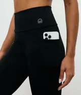 Calza deportiva tipo legging de tiro alto, color negro, confeccionada en microfibra térmica con bolsillo lateral funcional. Diseño liso y ajustado al cuerpo.