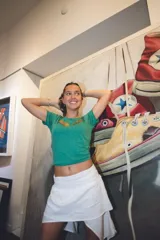 Remera verde de algodón de manga corta con aplique de alas doradas en el pecho.