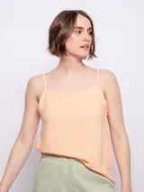 Top color durazno de breteles finos y escote con terminación ondulada.