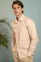 Camisa de manga larga en color salmón con estampado de pequeños motivos geométricos oscuros, cuello clásico y cierre frontal con botones.