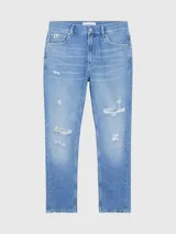 Pantalón de jean celeste con roturas, de corte recto y tiro medio.