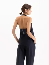 Top Lucille de silueta evasé, calce holgado y corte cropped, confeccionado en poplín Milano de algodón Pima. Cuenta con escote halter de sisa profunda, bretel regulable con ojalillos de níquel que envuelve el cuello, pinzas de entalle y espalda abierta.