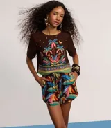 Short runner de tiro medio con cintura elástica y cordón ajustable. Confeccionado en una mezcla de viscosa y lino, presenta un estampado tropical colorido sobre fondo marrón, con bolsillos laterales y bajo redondeado.