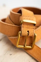 Cinto de cuero color marrón, con hebilla cuadrada dorada.