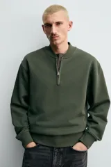 Sudadera de corte regular fit confeccionada en tejido de algodón con interior de rizo. Presenta cuello tipo rib, cierre frontal de cremallera y acabados en rib en puños y bajo.