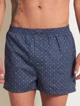 Bóxer de algodón blanco con estampado de flores pequeñas color celeste, con cintura elástica y logo de la marca en el centro.