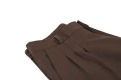 Pantalón de vestir azul marino, de corte recto, con bolsillos laterales y traseros. Se ajusta a la cintura con cinturón de cuero marrón. Tiene un cierre con botones en el tobillo.