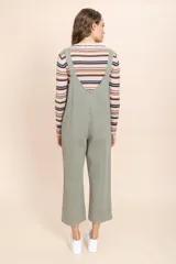 Mono enterizo verde oliva de corte holgado, con tirantes ajustables, bolsillo frontal y pernera ancha.