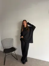 Buzo de punto color marrón chocolate, con cuello redondo y diseño holgado de manga larga con textura de trenzas verticales.