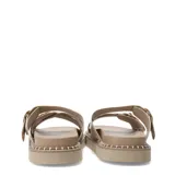 Sandalias planas Miss Carol modelo Zelv, color beige, con tiras anchas decoradas con hebillas metálicas doradas y tachas, sobre suela de plataforma baja con costuras visibles.