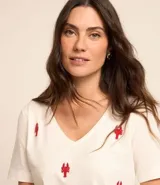 Remera de mangas cortas color crema, confeccionada en tejido flamé, con escote en pico y bordado delantero de langostas rojas.